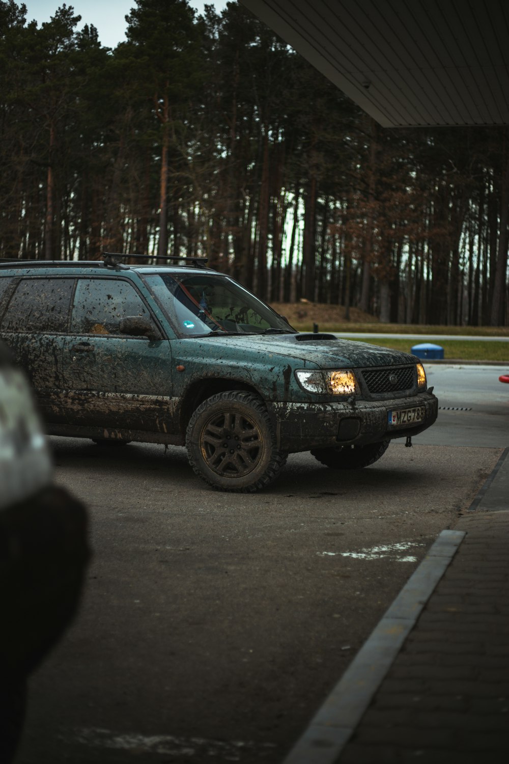 a green suv parked in a parking lot