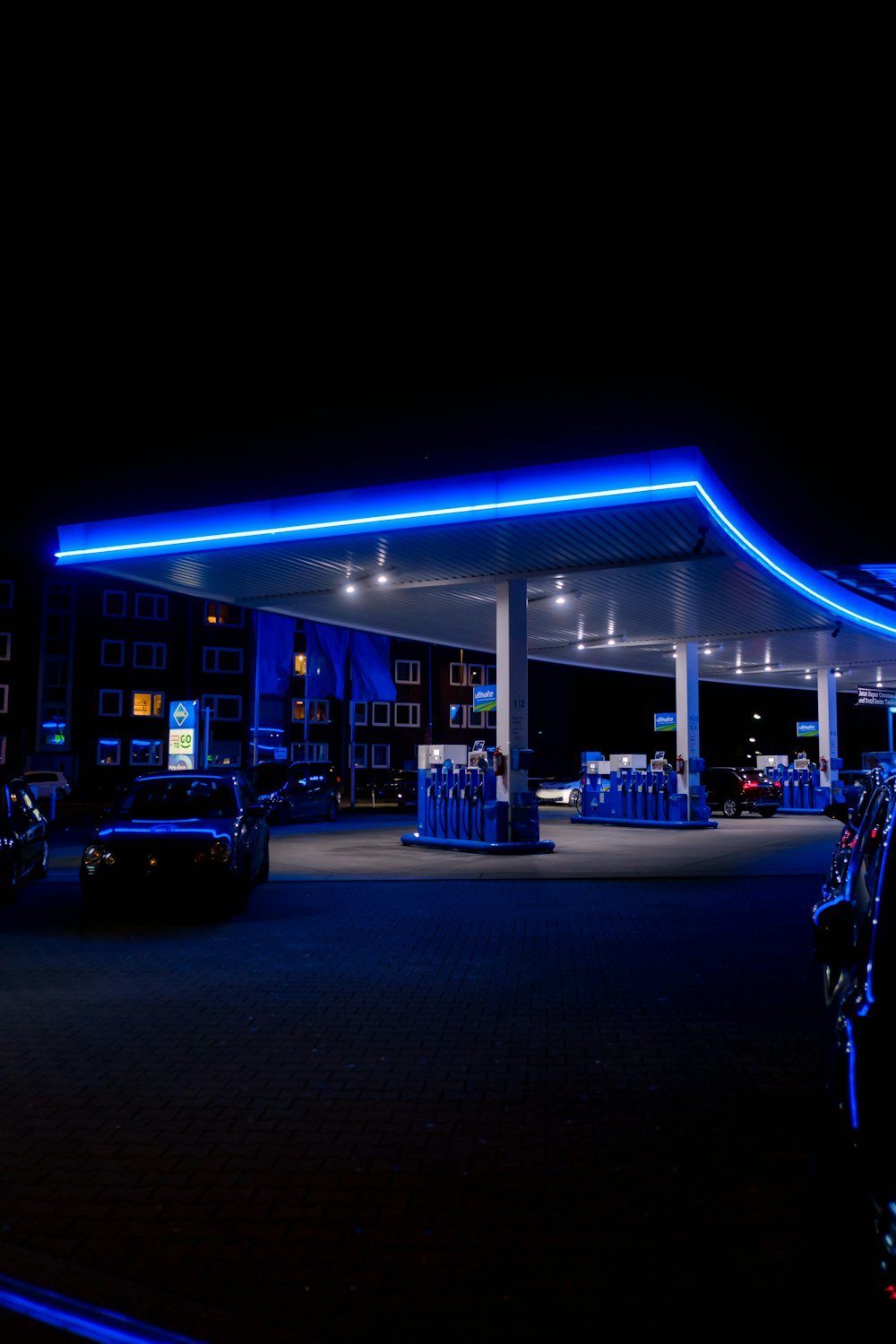 a gas station lit up at night with blue lights