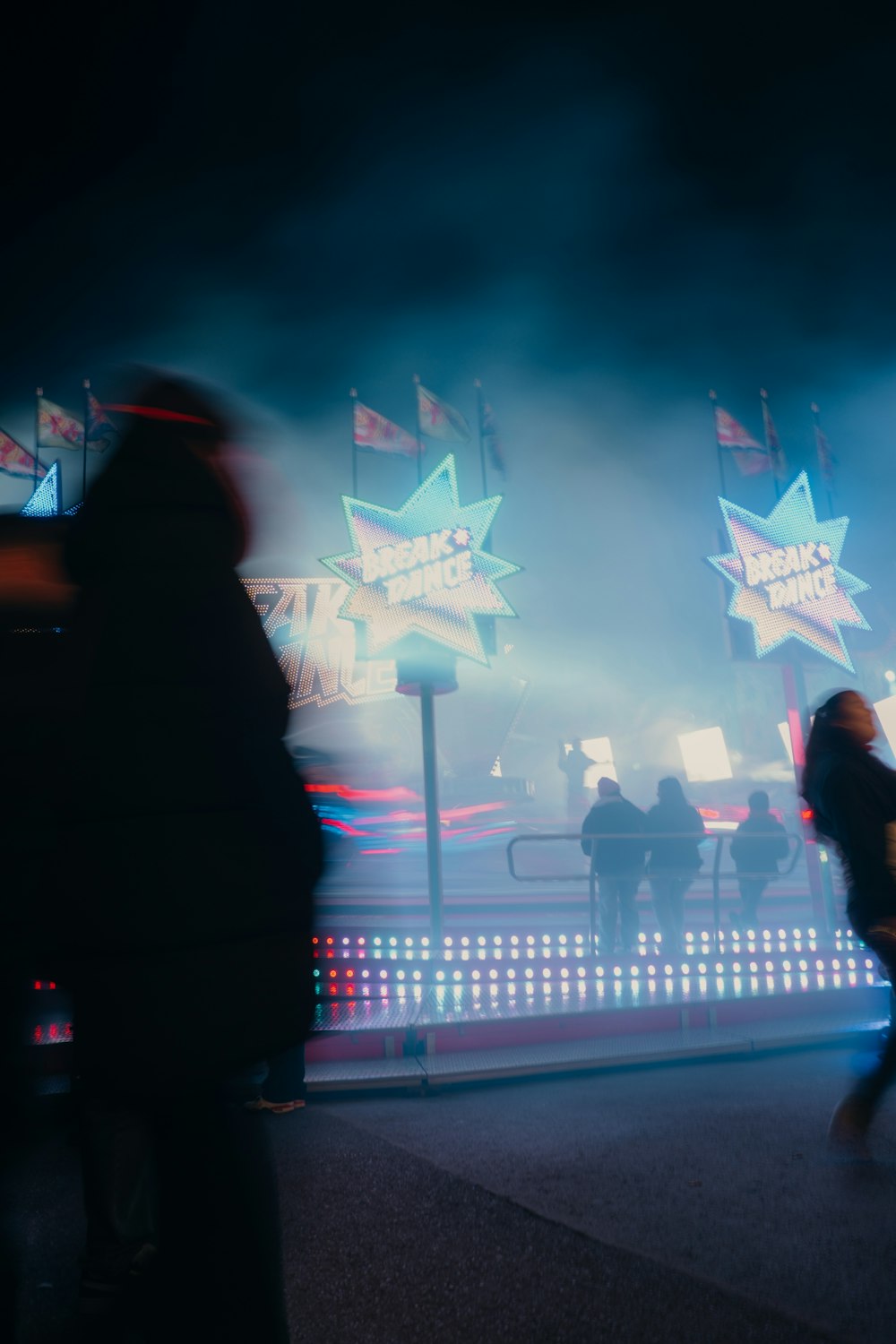 a group of people walking down a street at night