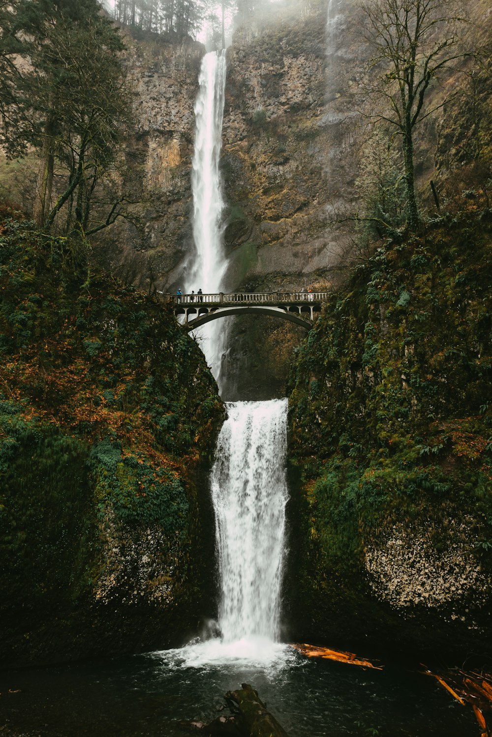 a large waterfall with a bridge over it