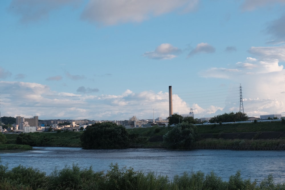 a body of water with a factory in the background