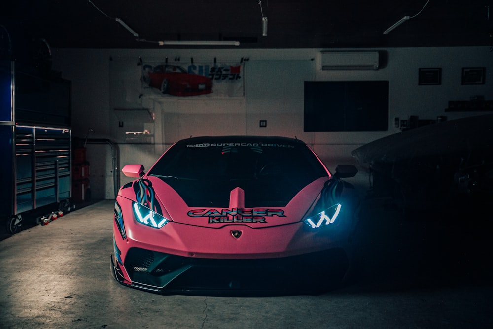 um carro esportivo rosa estacionado em uma garagem