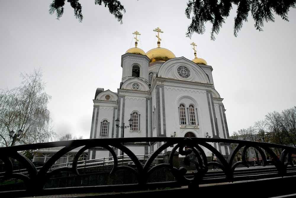 a large white church with gold domes on top of it