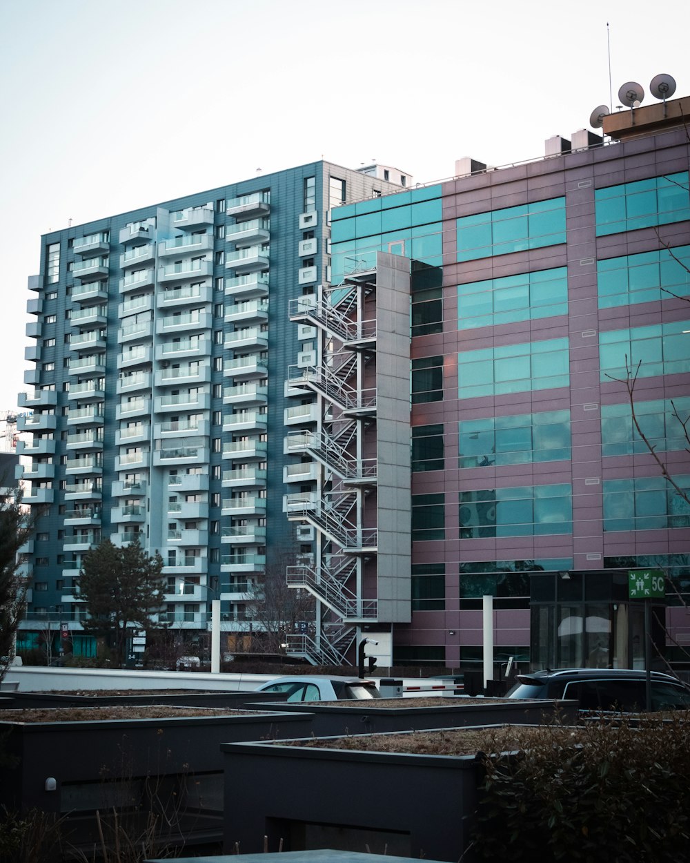 a tall building with a lot of windows next to a parking lot