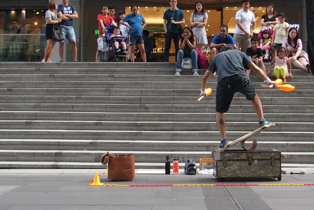 a man on a skateboard balancing on a suitcase