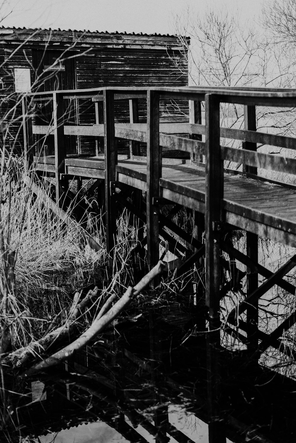 a black and white photo of a wooden bridge