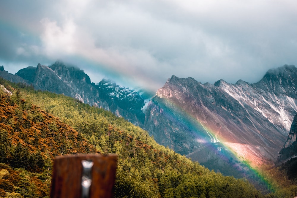 a rainbow in the sky over a mountain range