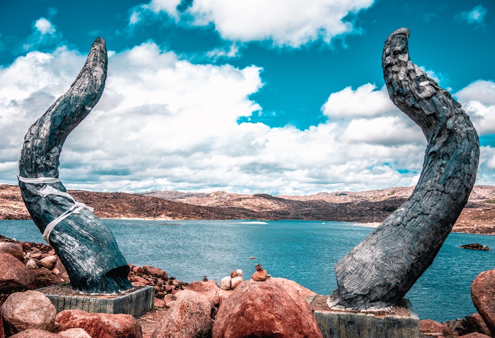 a couple of large rocks sitting next to a body of water