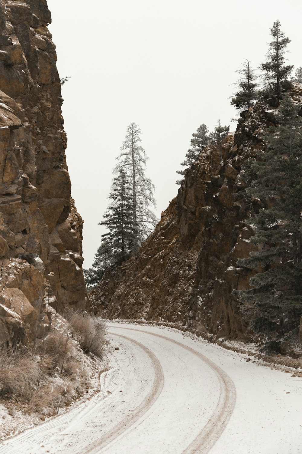 a snow covered road in the middle of a mountain
