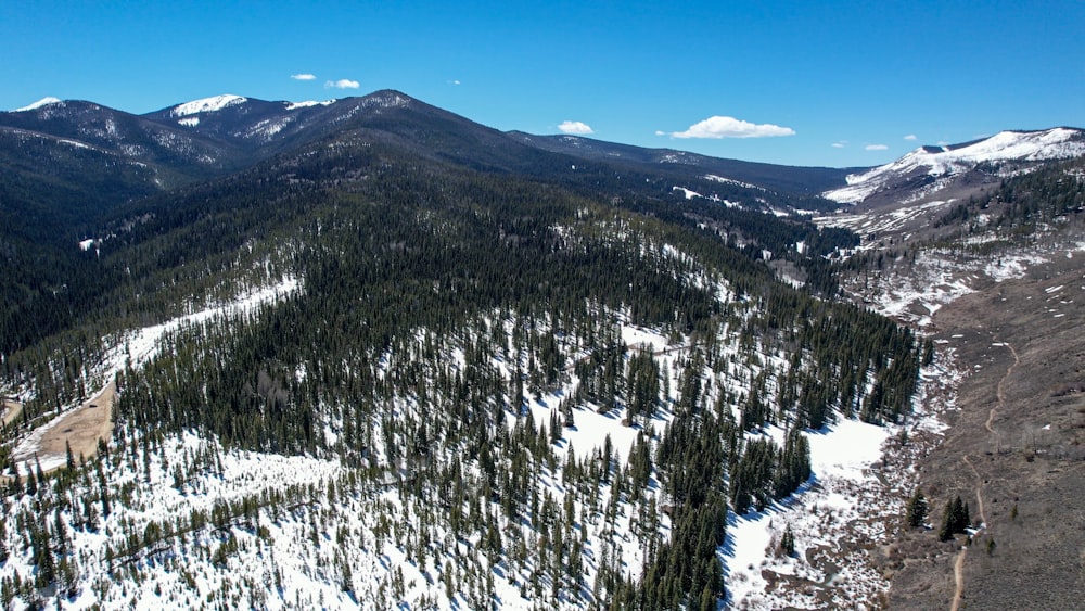Una vista de una cadena montañosa con nieve en el suelo