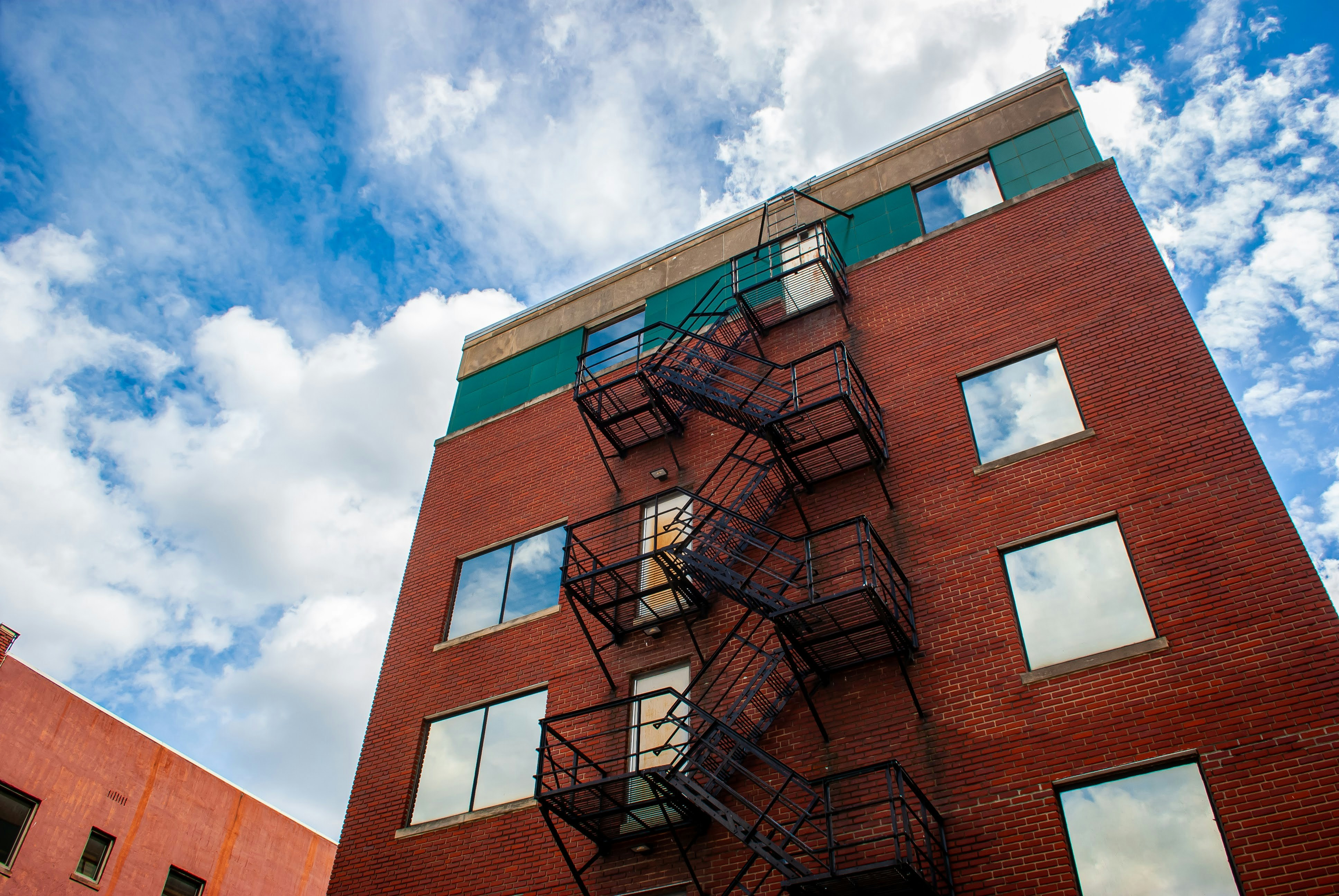 a tall red brick building with a fire escape