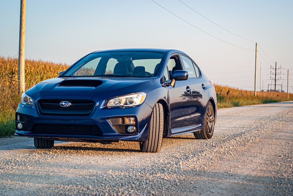 a blue subarunt is parked on the side of the road