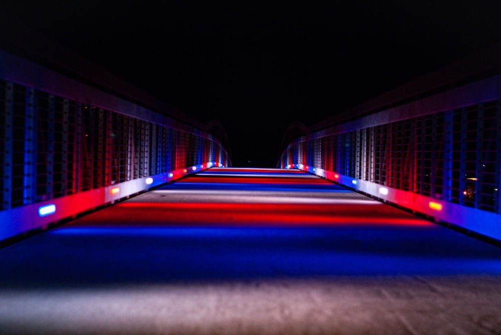 um longo corredor com luzes vermelhas, brancas e azuis