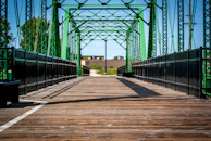 a bridge that has a green metal structure on top of it