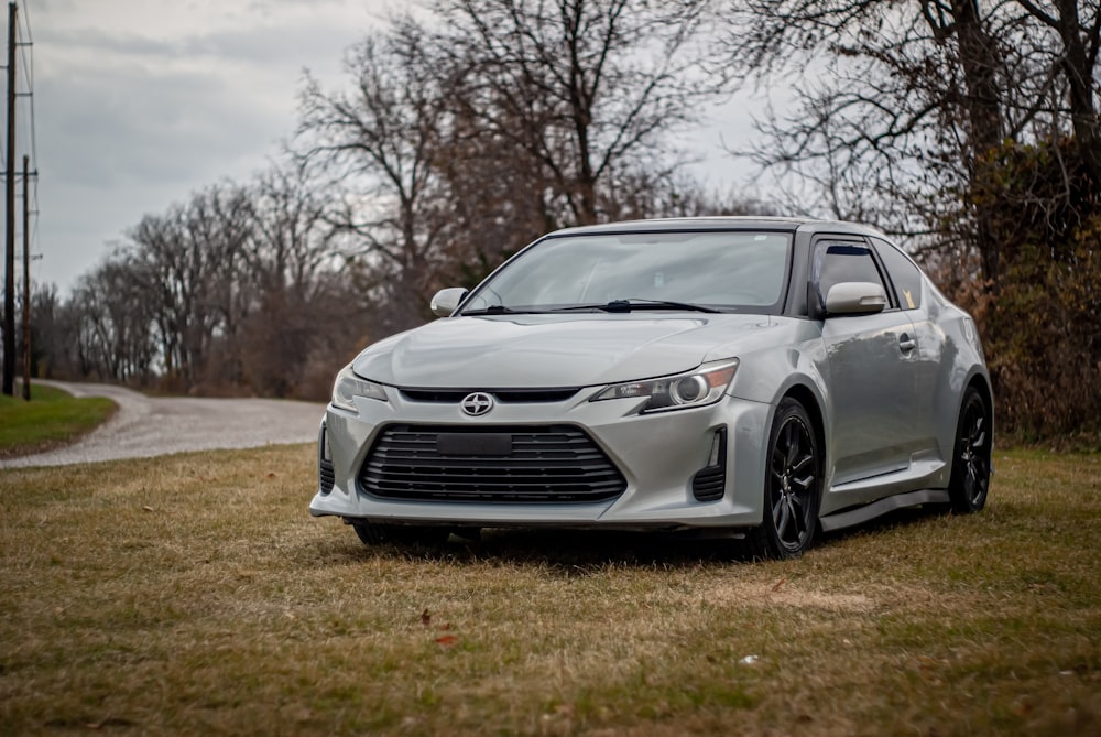 a silver car is parked on the grass