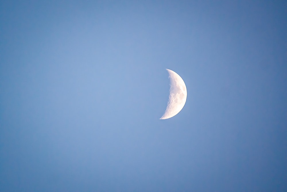 une demi-lune dans un ciel bleu clair