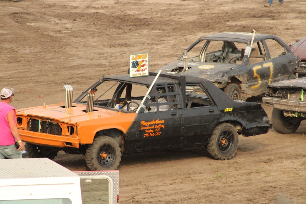 a man standing next to an orange and black truck