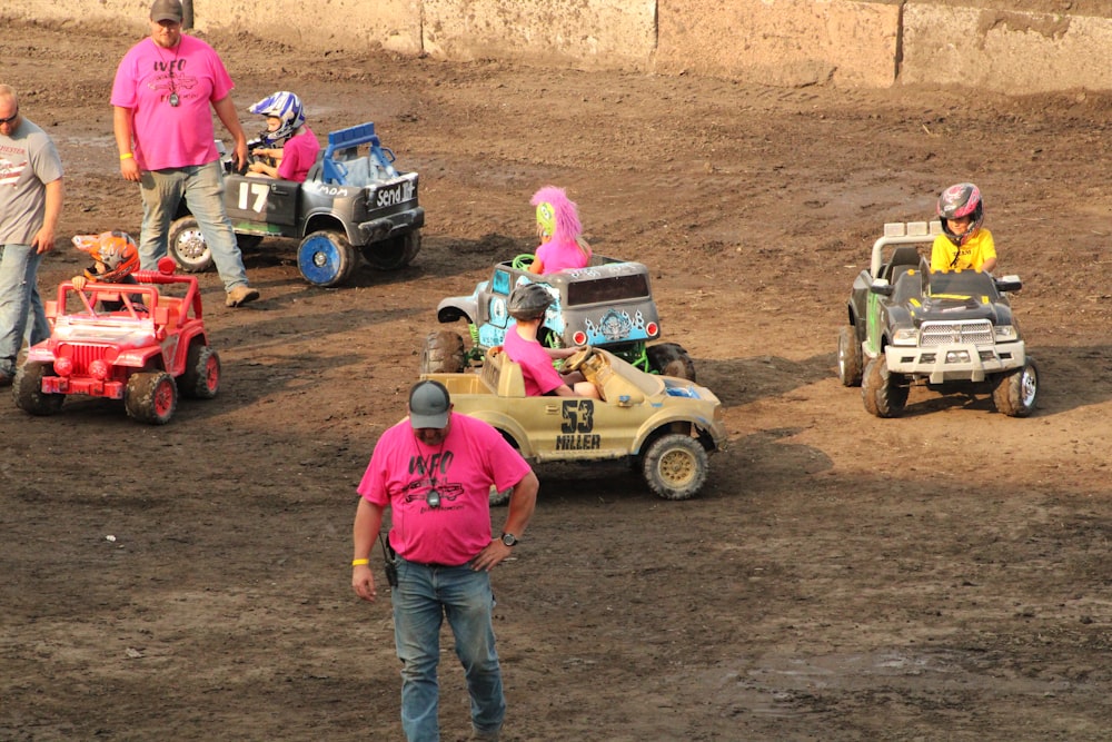 a group of people in pink shirts standing around a dirt field