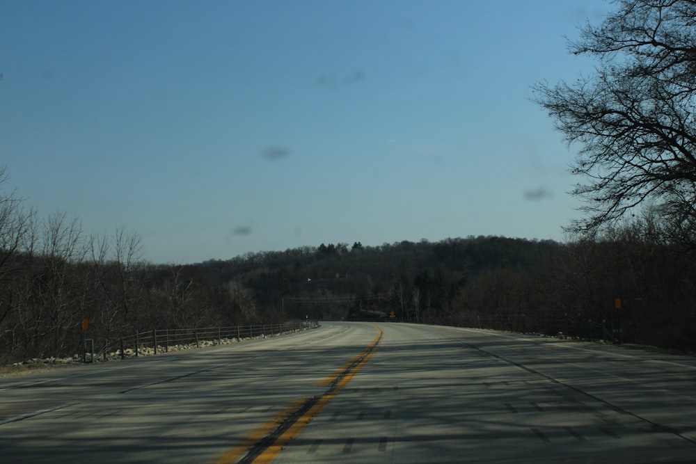 a view of a road with trees and a hill in the distance