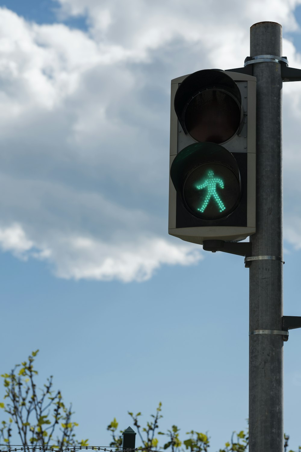 a traffic light with a green pedestrian sign on it