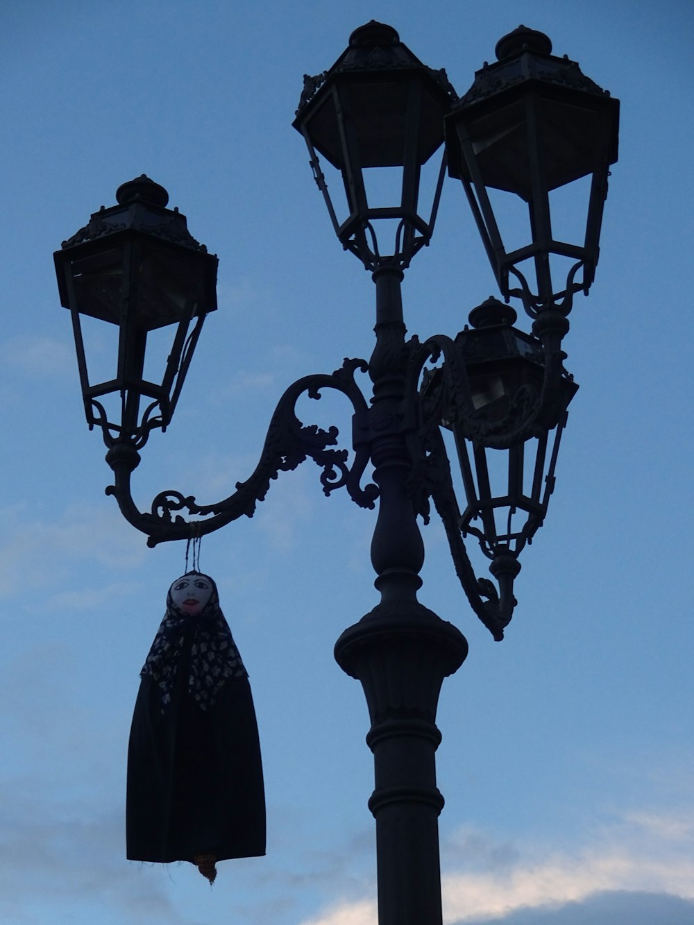 a street light with a hat hanging off of it's side