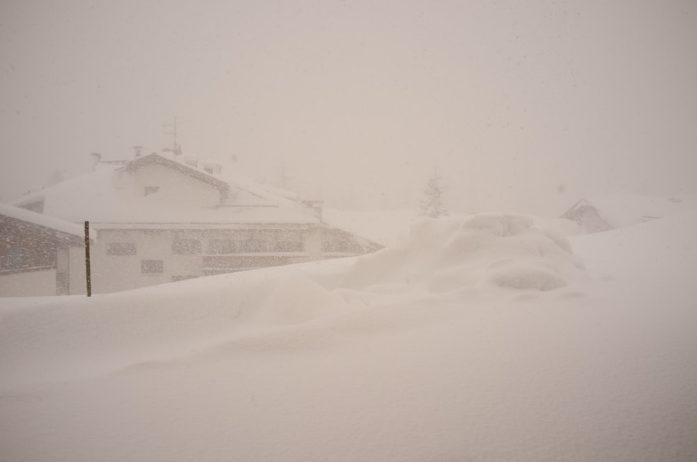 a snow covered hill with a house in the background