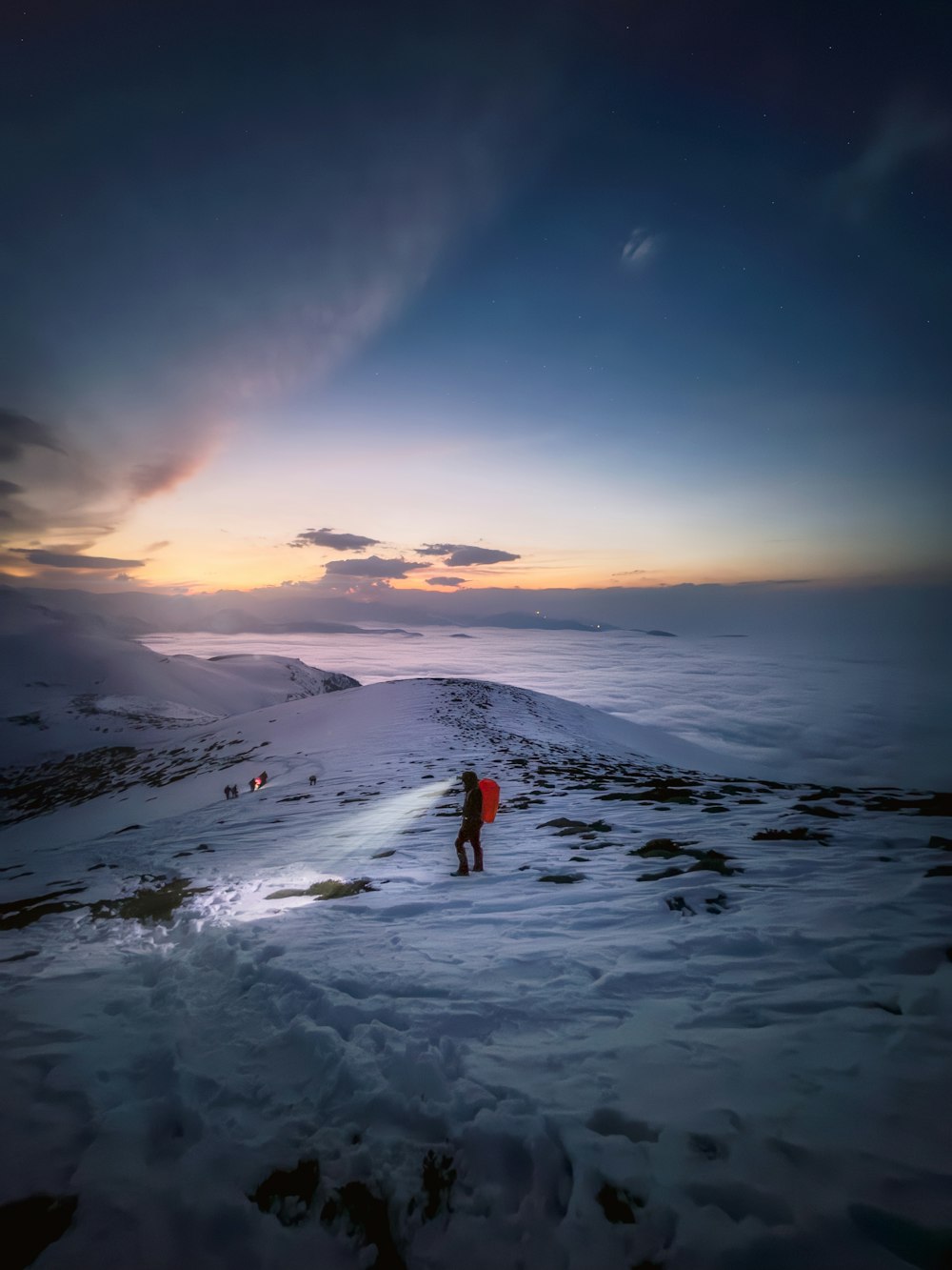 una persona de pie en una colina cubierta de nieve