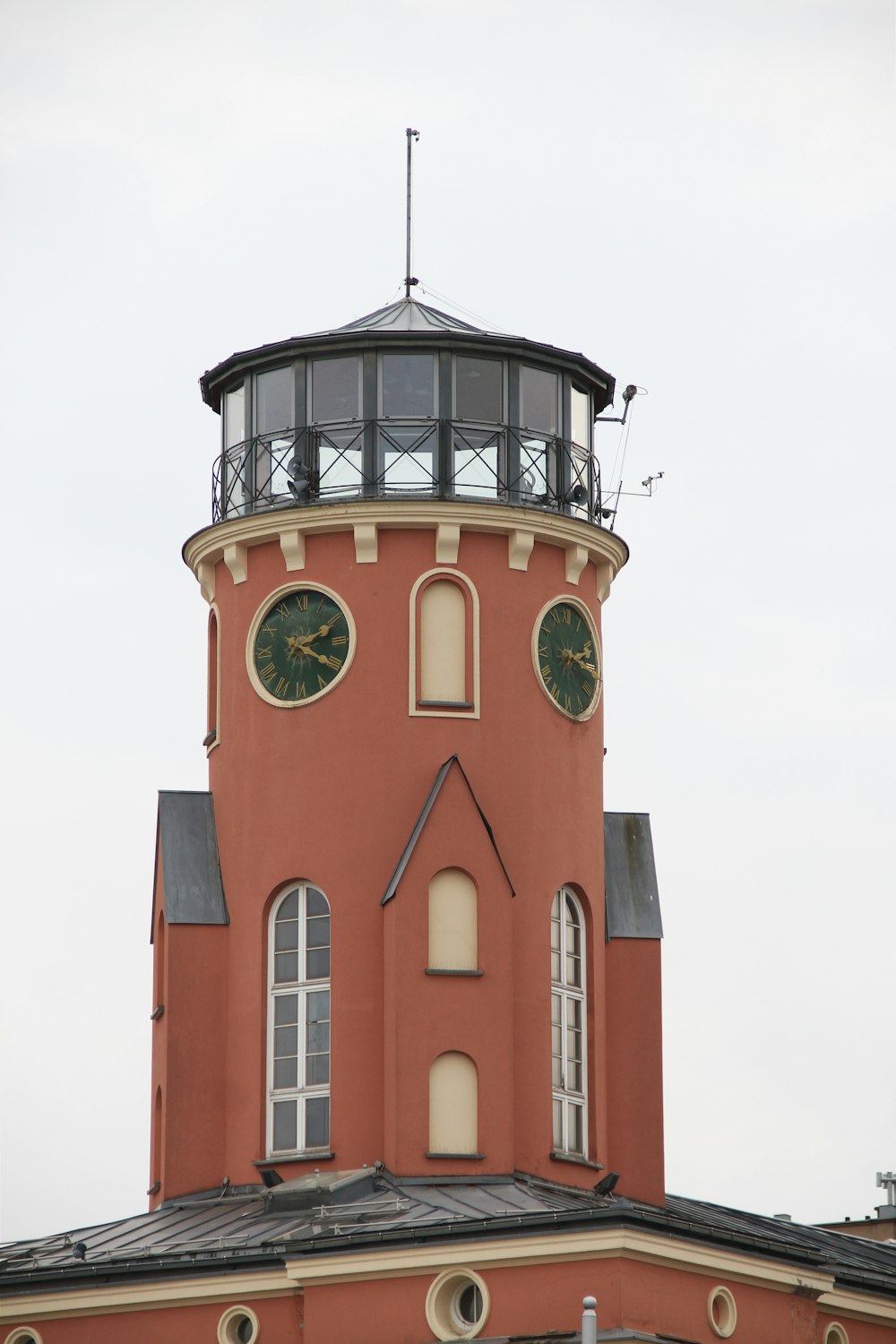 a tall red building with a clock on the top of it