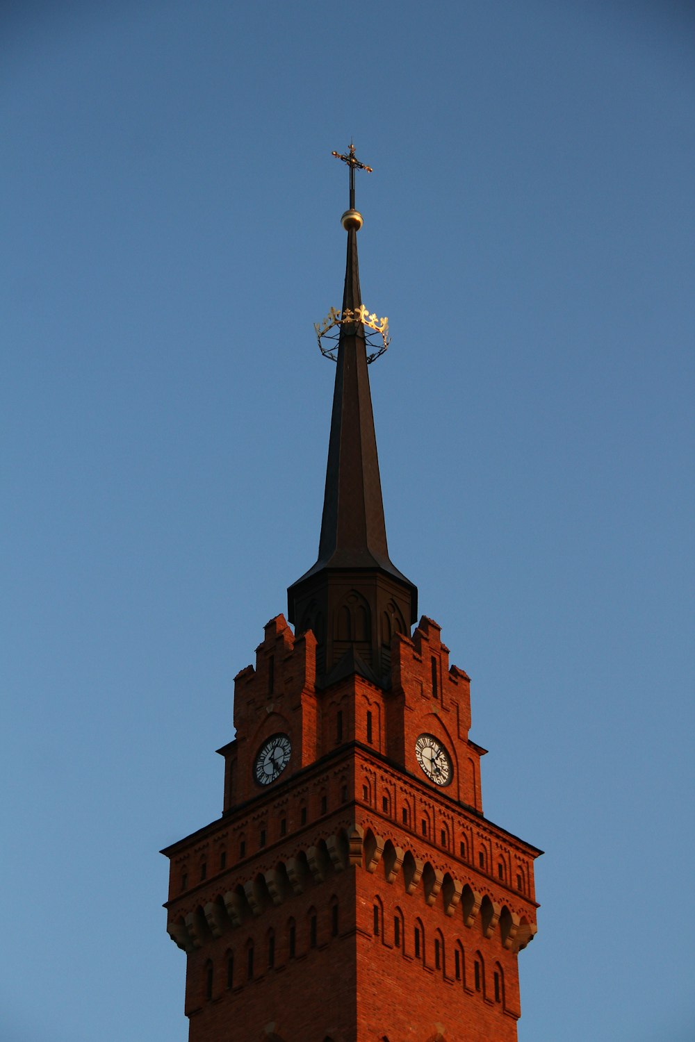 a tall clock tower with a weather vane on top