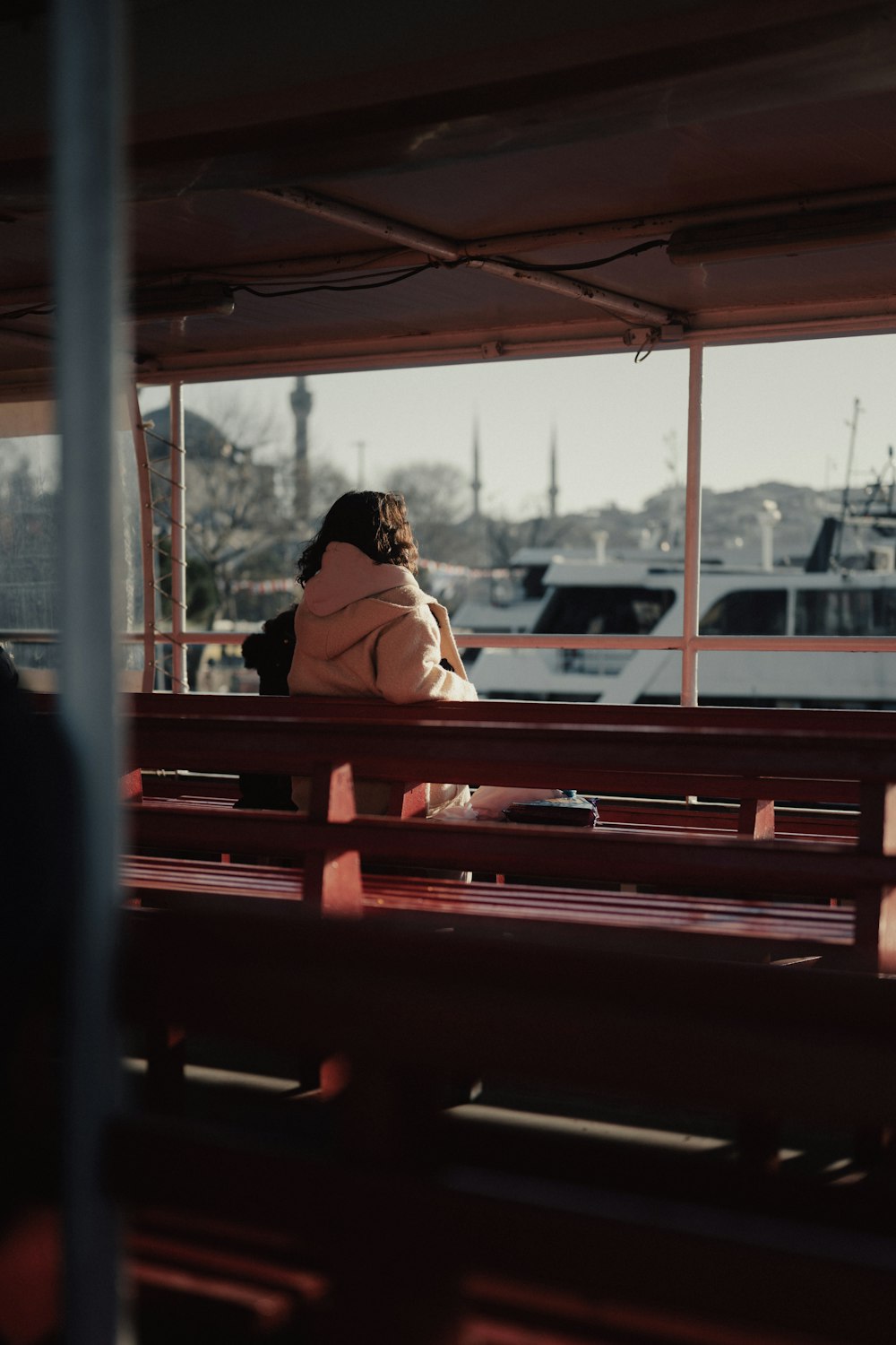 a woman sitting on a bench in front of a window