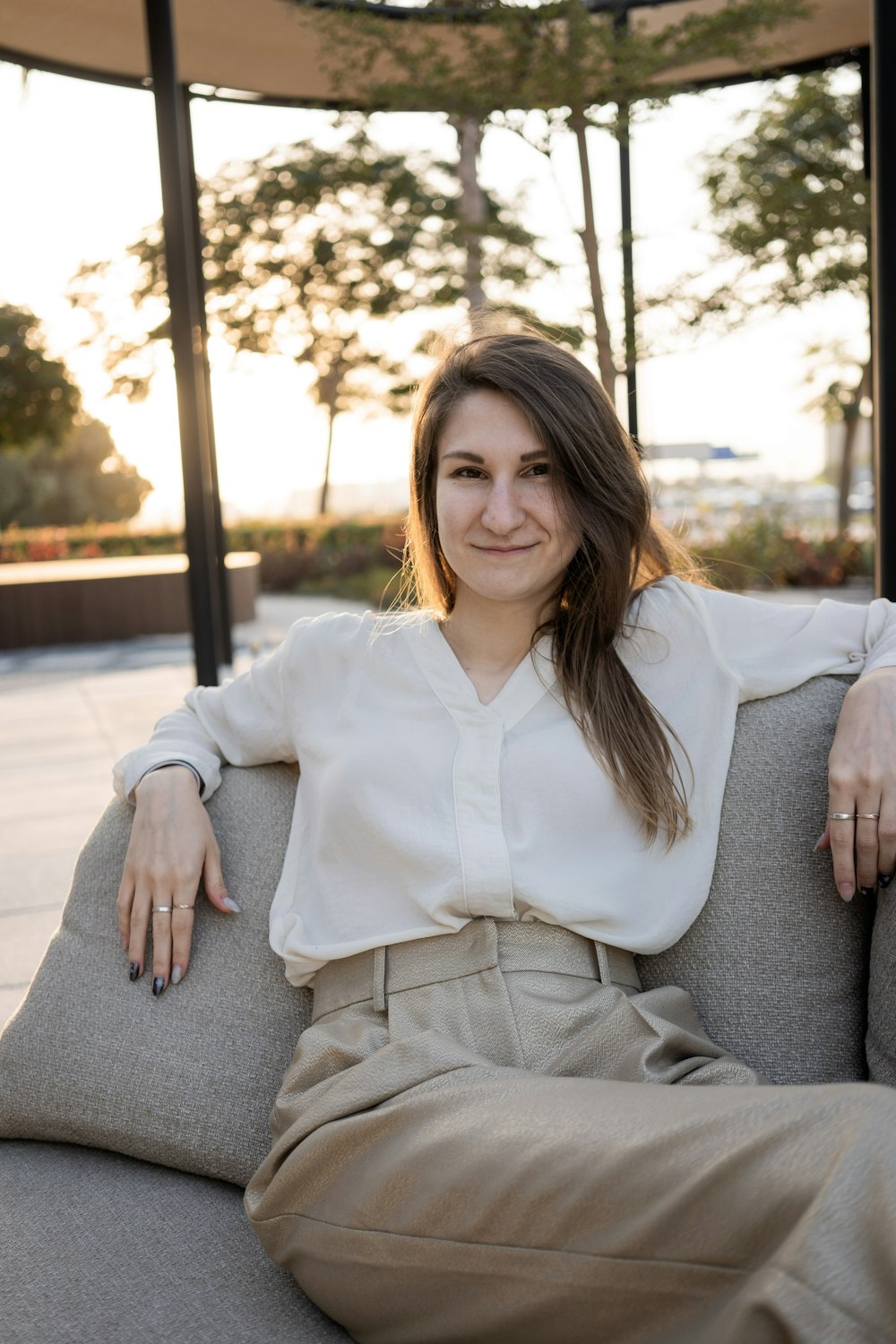 a woman sitting on top of a gray couch