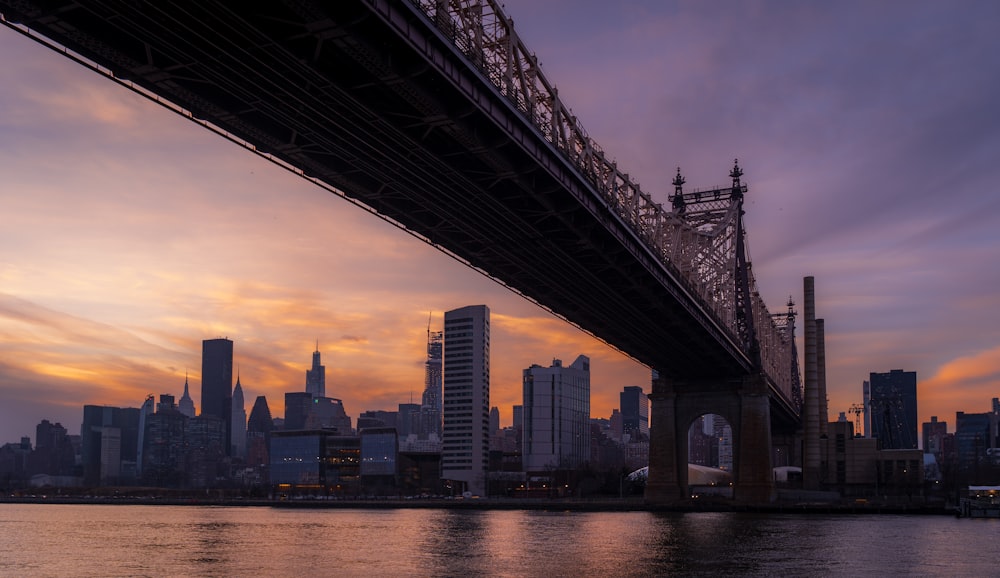 a bridge over a body of water with a city in the background