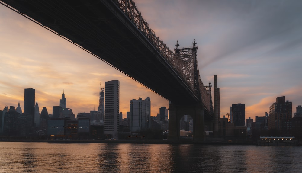 a bridge over a body of water with a city in the background