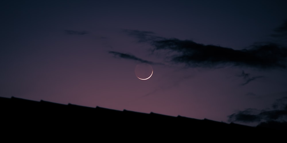 a crescent is seen in the night sky