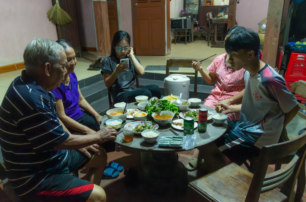 a group of people sitting around a table eating food