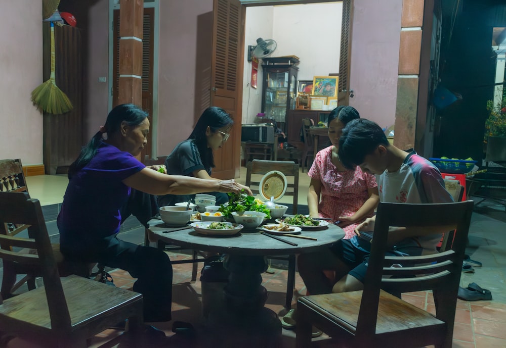 a group of people sitting around a table eating food