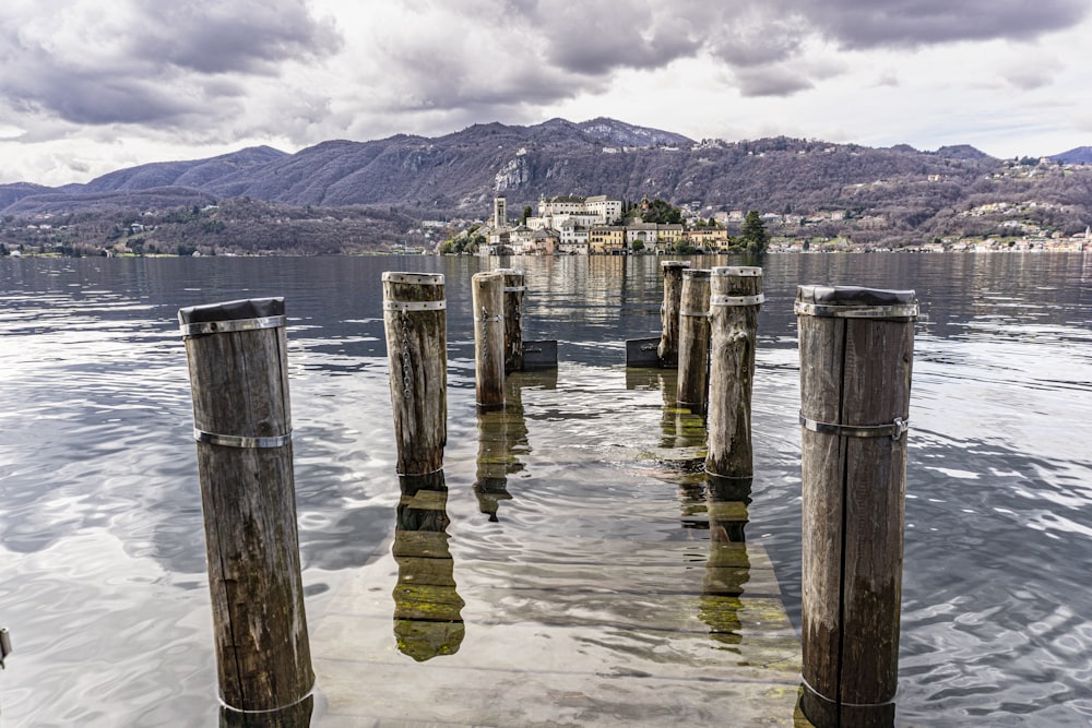 a body of water with wooden posts sticking out of it