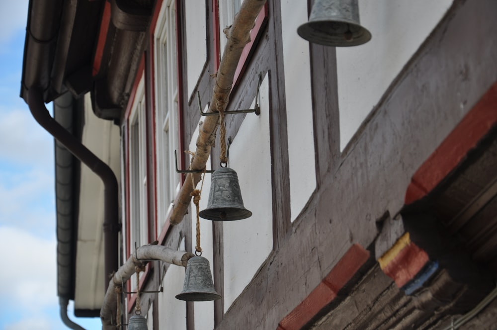 a row of bells hanging from the side of a building