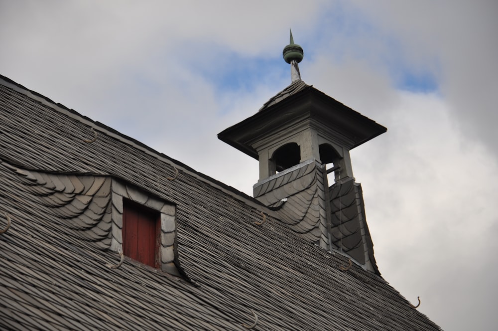 the roof of a building with a weather vane on top of it