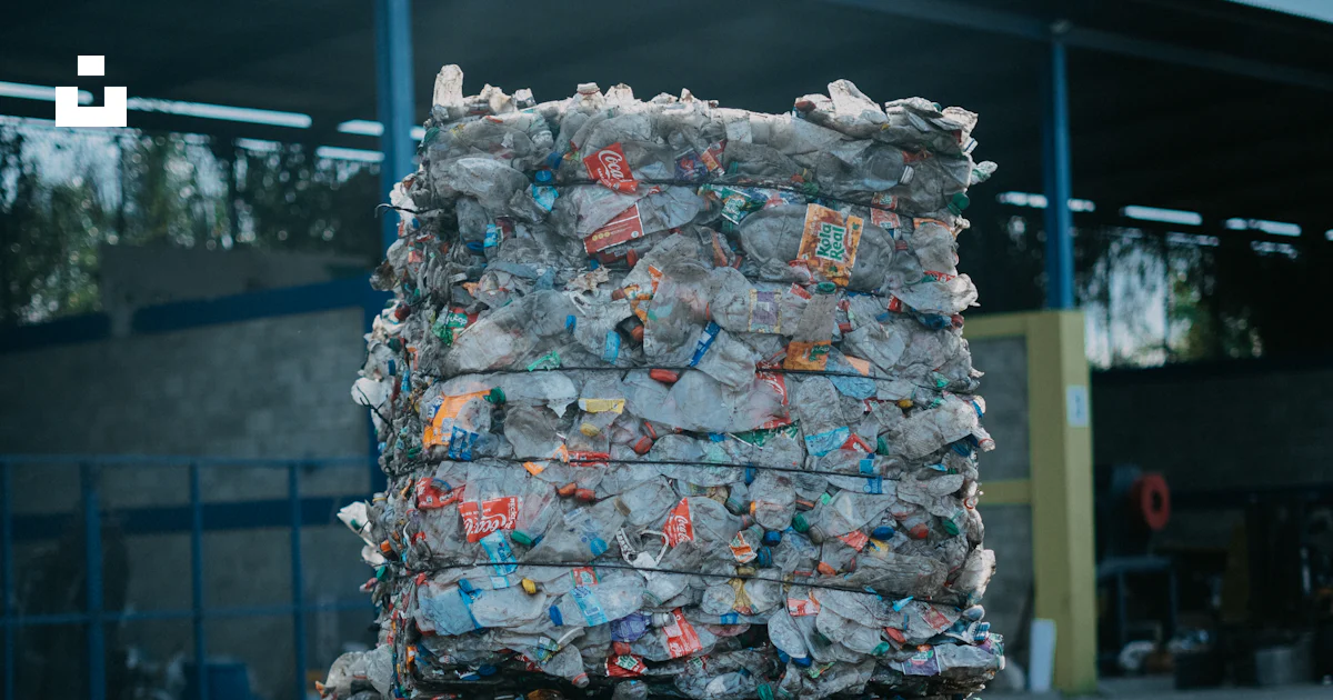 A large stack of garbage sitting in front of a building photo – Free ...