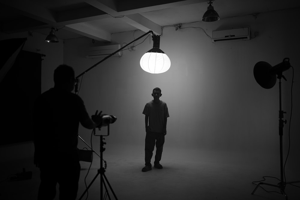 a man standing in front of a light in a dark room