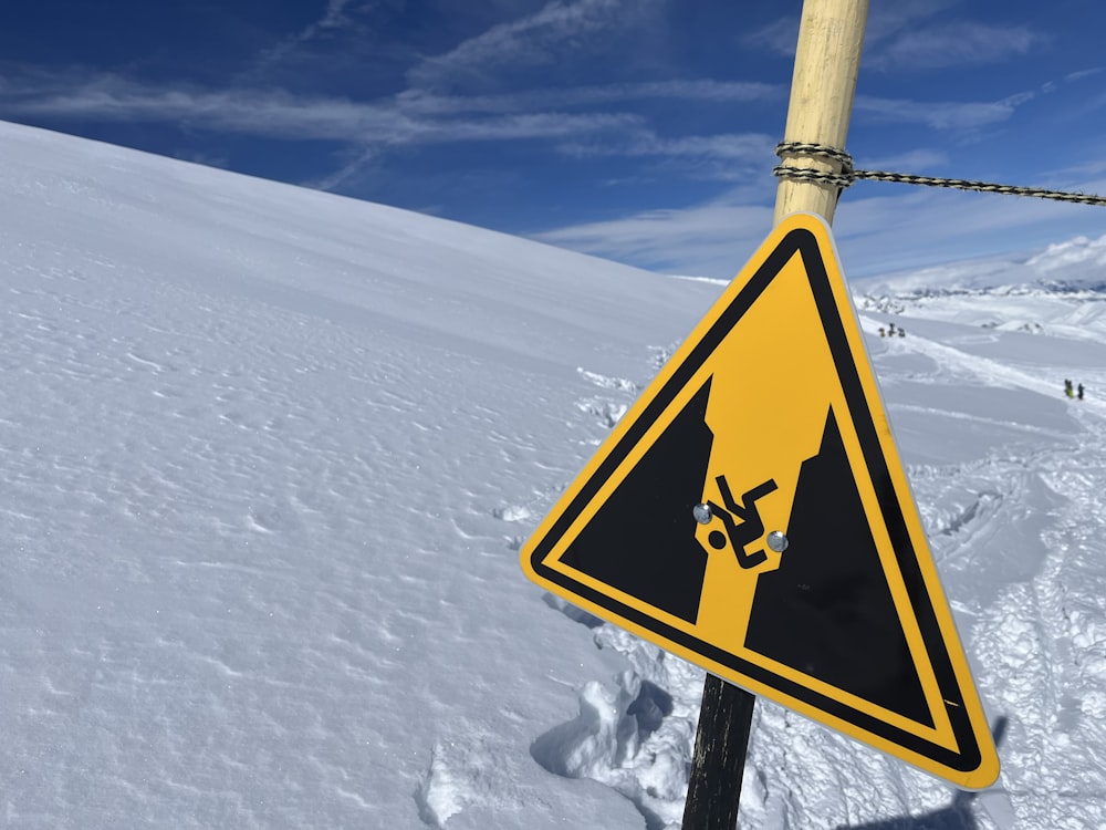 a warning sign on a pole in the snow
