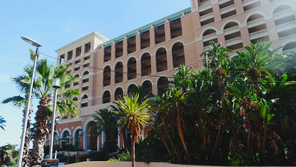 a large building with a lot of palm trees in front of it