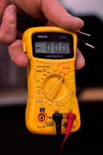 a person holding a multimeter in their hand