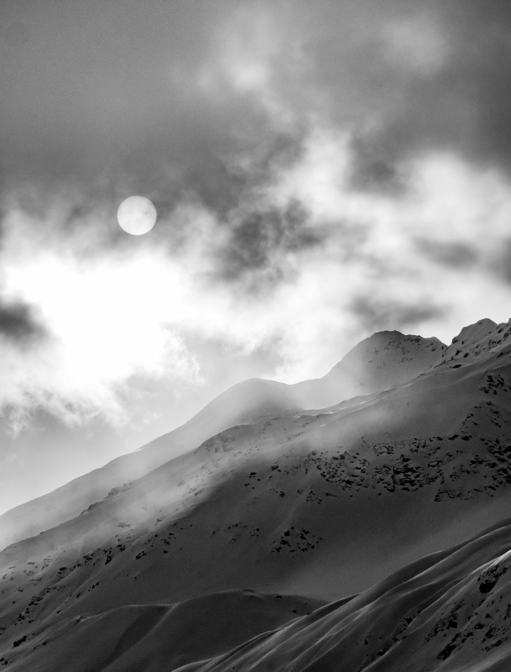 a black and white photo of a snow covered mountain