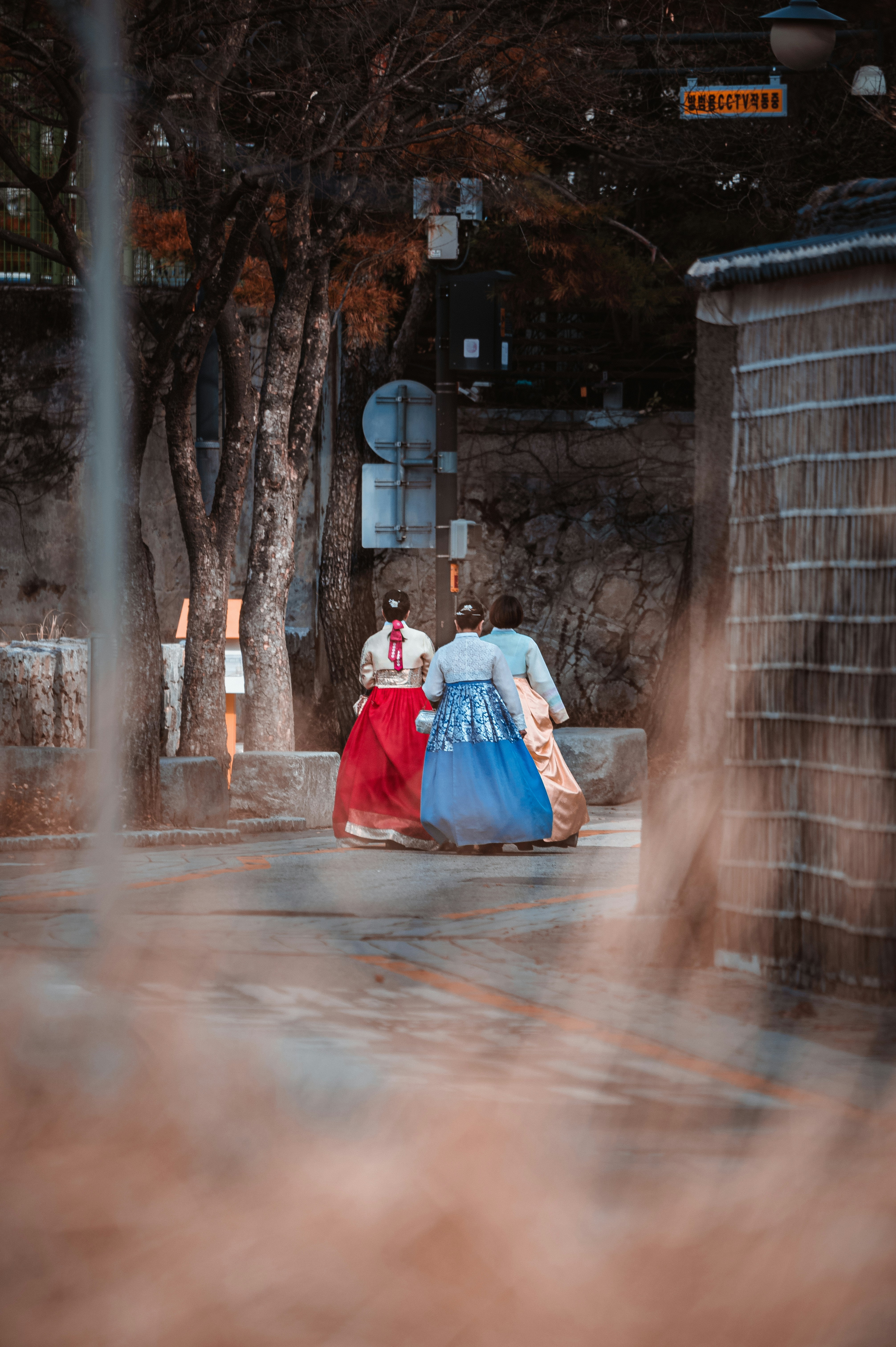 A couple of women walking down a street photo – Free Woman Image on ...