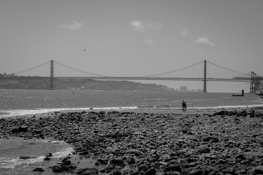 a black and white photo of a person walking on the beach,