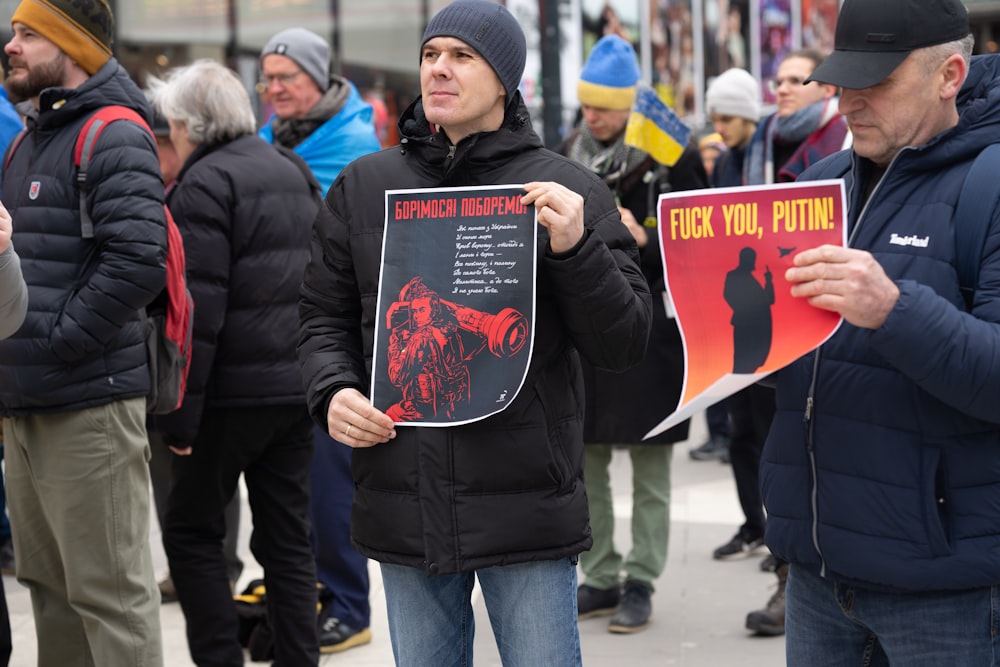 a man holding a sign in front of a crowd of people