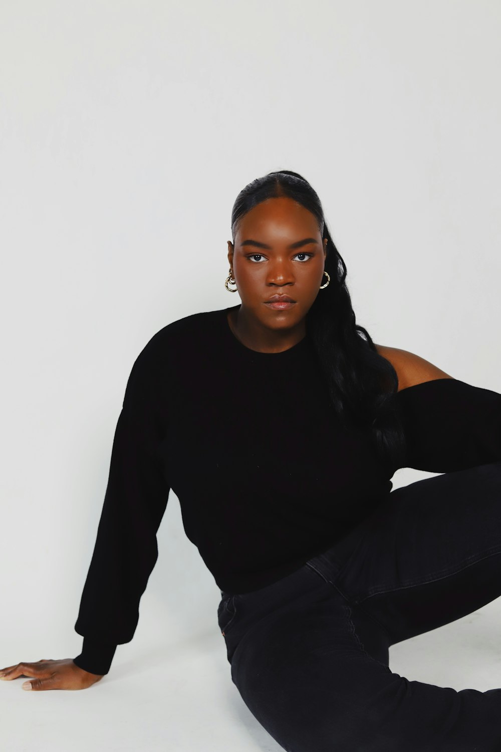 a woman sitting on the ground with her legs crossed