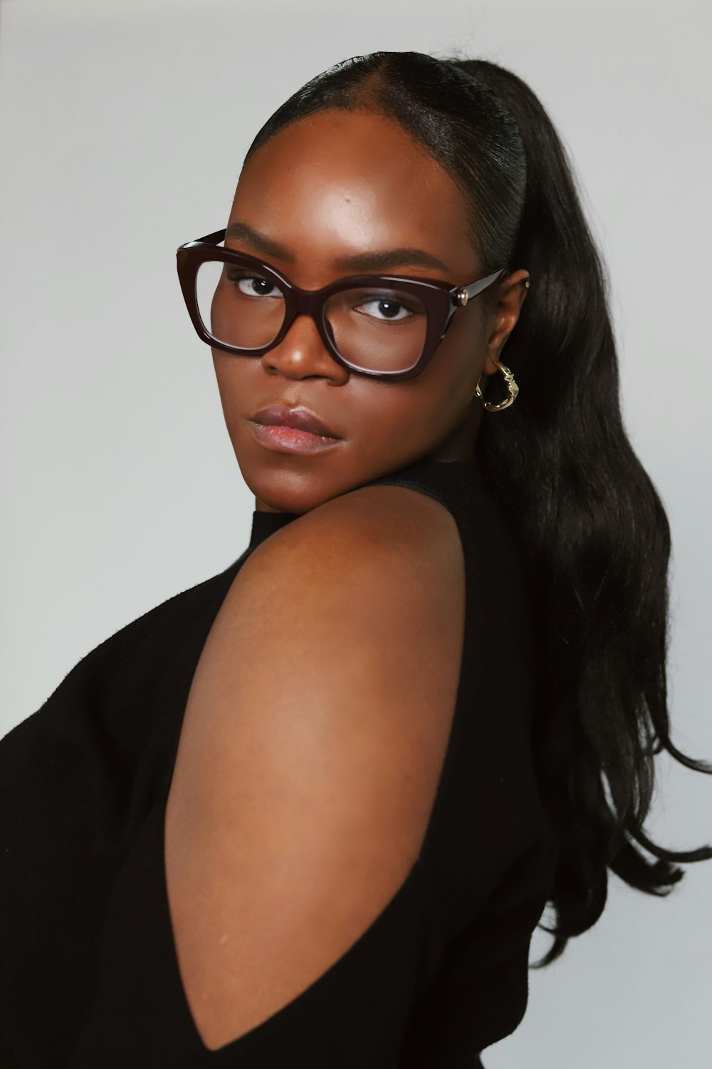 a woman wearing glasses and a black top
